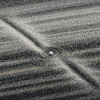Conceptual illustration of an icy moonlet amid the fine silver particles of Saturn’s A ring, with two elongated offset disturbances extending away on opposite sides. The granular ring lanes and dark partial clearings evoke a propeller-shaped footprint; this is an artistic visualization, not a Cassini photograph or a scale simulation.